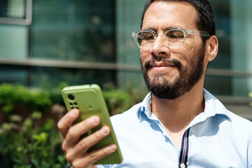 Businessman using smartphone app outside office building