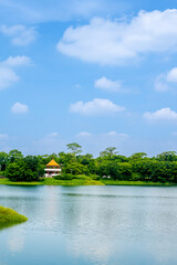Fototapeta premium Tranquil morning view across Lantan Reservoir’s glassy water, lush tree-lined banks and soft summer sky reflecting the serene beauty of this popular scenic lake and recreation area.
