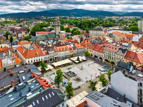 Aerial view of historic town square in Bielsko-Biała, Poland with colorful buildings and mountains in the background.