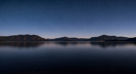 Majestic Lake, Distant Mountains, and Celestial Starry Sky Panorama
