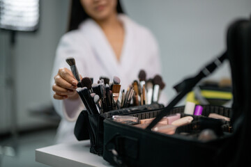 Makeup artist picking a brush from a professional makeup case