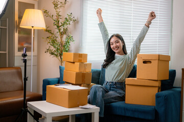 Young asian woman celebrating success of her online store selling products