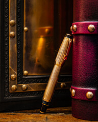 Large black and purple leather books with a golden fountain pen. Pen reflection in a polished brass plate in a black book.