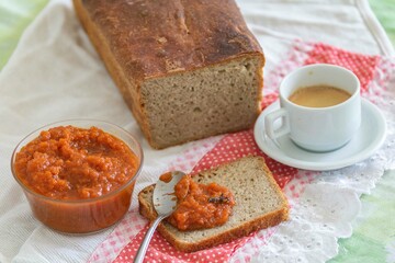 Rustic colonial rye bread, with chimia or pumpkin jam. Well-lit image, clear selective focus on the details of the texture of the bread and the jam, conveying tradition, rusticity and homemade flavor