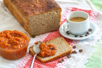 Rustic colonial rye bread, with chimia or pumpkin jam. Well-lit image, clear selective focus on the details of the texture of the bread and the jam, conveying tradition, rusticity and homemade flavor