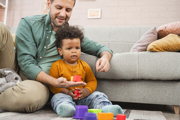 Multiracial family playing with colorful building blocks at home