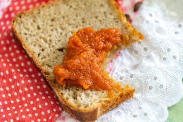 Rustic colonial rye bread, with chimia or pumpkin jam. Well-lit image, clear selective focus on the details of the texture of the bread and the jam, conveying tradition, rusticity and homemade flavor