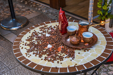 A Bosnian coffee set (kahveni takum) with copper cezve and cups on a table in old town of Sarajevo