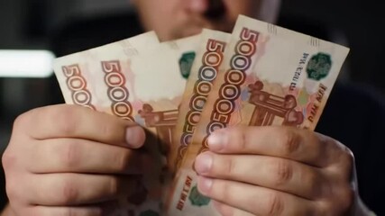 Man counts 5000 Russian ruble banknotes — close-up shot of cash, symbolizing bribery, corruption, or financial dealings. - Powered by Adobe