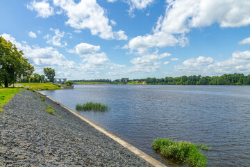 River landscape with embankment and blue sky on a sunny day