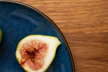 Halved fig on blue plate close-up
