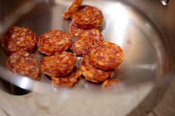 Sliced chorizo in stainless steel pot
