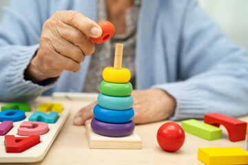 Alzheimer disease AD, Asian elderly woman patient suffering from dementia learn practical motor...