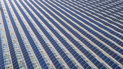 Greenhouse for growing vegetables with mounted photovoltaic solar panels on the roof, combining agriculture and solar energy for sustainable and eco-friendly food production.