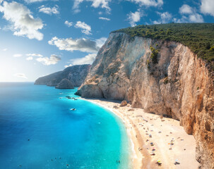Aerial view of blue sea, rock, sandy beach at sunset in summer. Porto Katsiki, Lefkada island, Greece. Beautiful landscape with sea coast, azure water, sky, clouds. Top view of shore. Travel