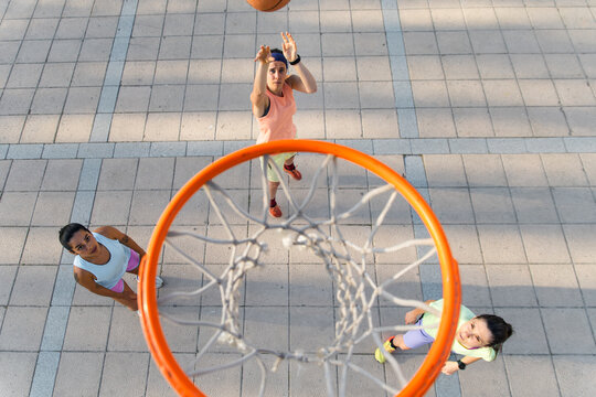 Women playing street basketball in high spirits