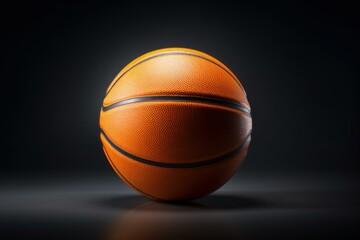 Obraz premium Orange basketball ball resting on dark background with dramatic lighting, perfect for sports concepts