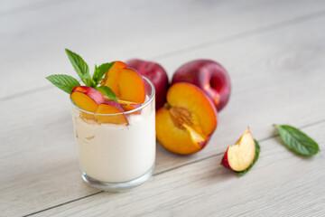 Whole and cut nectarines with yogurt on light wooden table