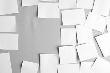 White Paper Notes Scattered on Grey Background Creative Workspace Concept