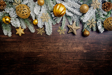 Christmas and New Year background with a festive scene with gold and red Christmas ornaments and fir tree branches on a wooden background, symbolizing holiday spirit and elegance.