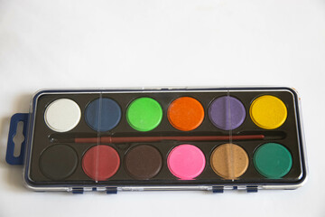 Palette of watercolor paints close-up on a white background. For beginner artists and school...