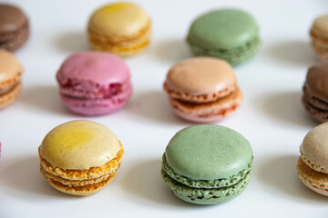 Macaroons, colorful cookies with buttercream close-up on a white background.Made from egg whites, powdered sugar, sugar syrup, ground almonds and food coloring.Each color corresponds to its own taste.