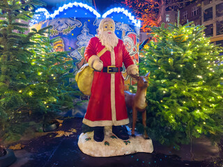 Santa Claus figure on the christmas market with christmas trees in the old town of Limburg at night