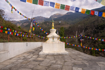 White buddhist Stupa with tradition tibetan prayer flags in Himalayan landscape - Spisritual scene in Nepal mountains.
