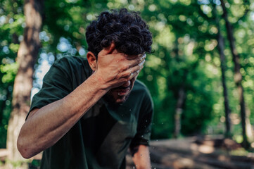 Soldier refreshing himself washing face with water in forest