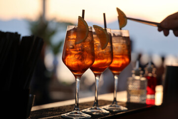 sunset aperitif, cocktail with ice and orange slice
