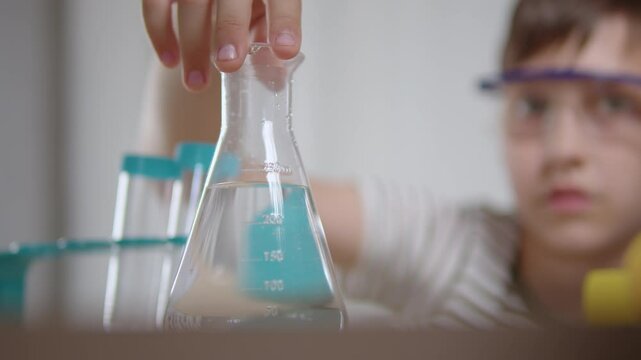 Schoolboy holding flask during science experiment