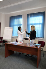 Two women meet to discuss a project and sign a contract.