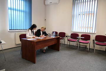Two women meet to discuss a project and sign a contract.