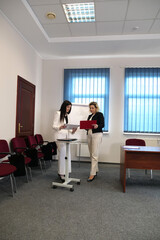 Two women meet to discuss a project and sign a contract.