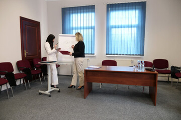 Two women meet to discuss a project and sign a contract.