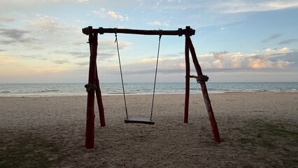 swing on the beach,a couple watching the sunset on the beach on a swing,white tropical beach during sunset,swing on the beach during sunset,Empty hammock swing on the beautiful beach and sea