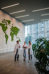 Doctors walking and discussing diagnosis in hospital lobby with world map