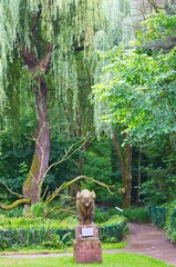  Santillana Zoo commemorative statue under large trees.