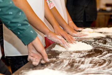 Women's hands smeared in flour and flour on the table