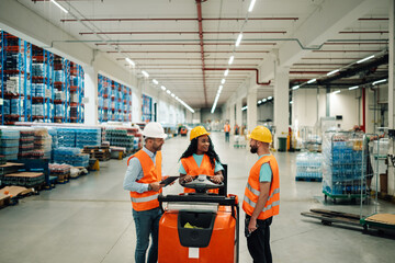 Warehouse workers discussing logistics on forklift in bottled water storage