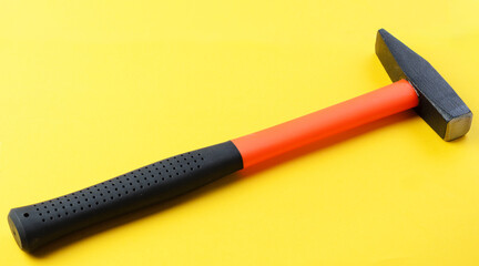 Single metal hammer on yellow background, top view, construction tool with copy space