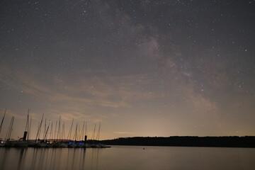 Starry Night Sky over Quiet Marina with Reflections on the Water
