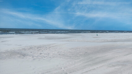 The vast sandy beach -Leba on the Baltic Sea coast is a popular tourist destination especially in the summer.  
Minimalism.  A figure is visible in the distance