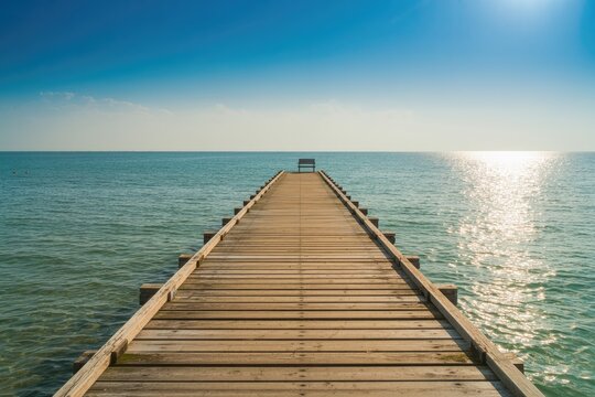 Fototapeta Seascape Straight wooden dock pier with bench extending over water to the horizon