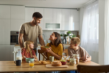 Happy family enjoying while having breakfast  in dining room. 
