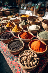 colorful spice assortments in baskets on a patterned cloth at a market