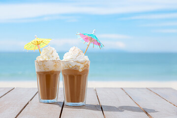 Beachside Coffee. Two iced coffees with whipped cream on a wooden table