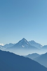 Majestic Mountain Range with Clear Blue Sky and Soft Foggy Horizon