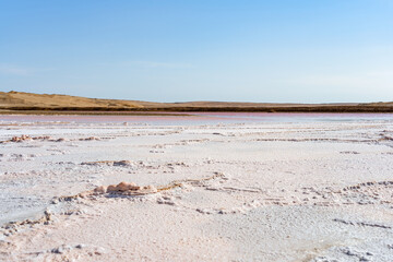 View of the pink salt lagoon set against the desert dunes in Paracas National Reserve, Peru.