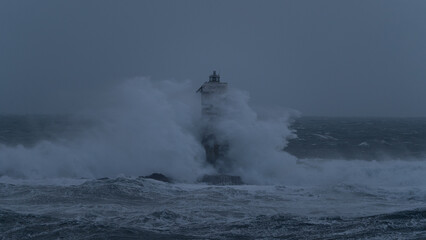 Powerful ocean waves smashing into isolated lighthouse during heavy sea storm